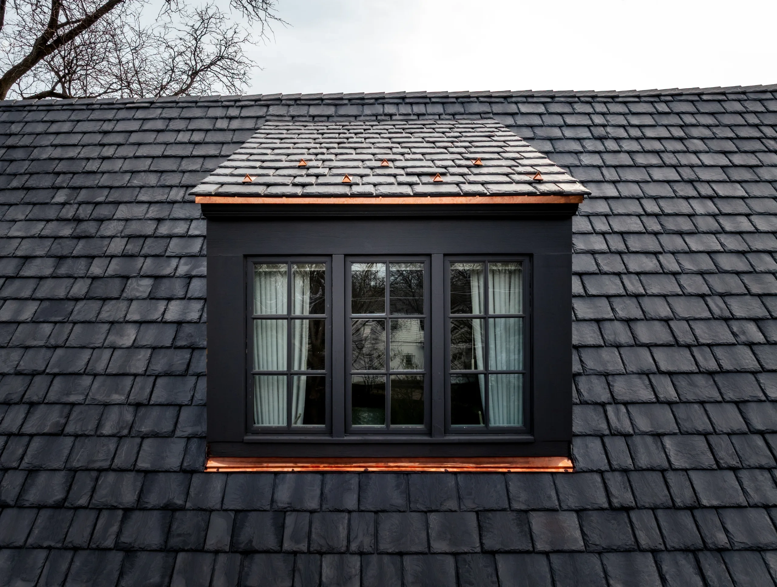 Close view of Brava synthetic slate courses, staggered edges, ridge pieces, and copper dormer detailing on the Hinsdale residence