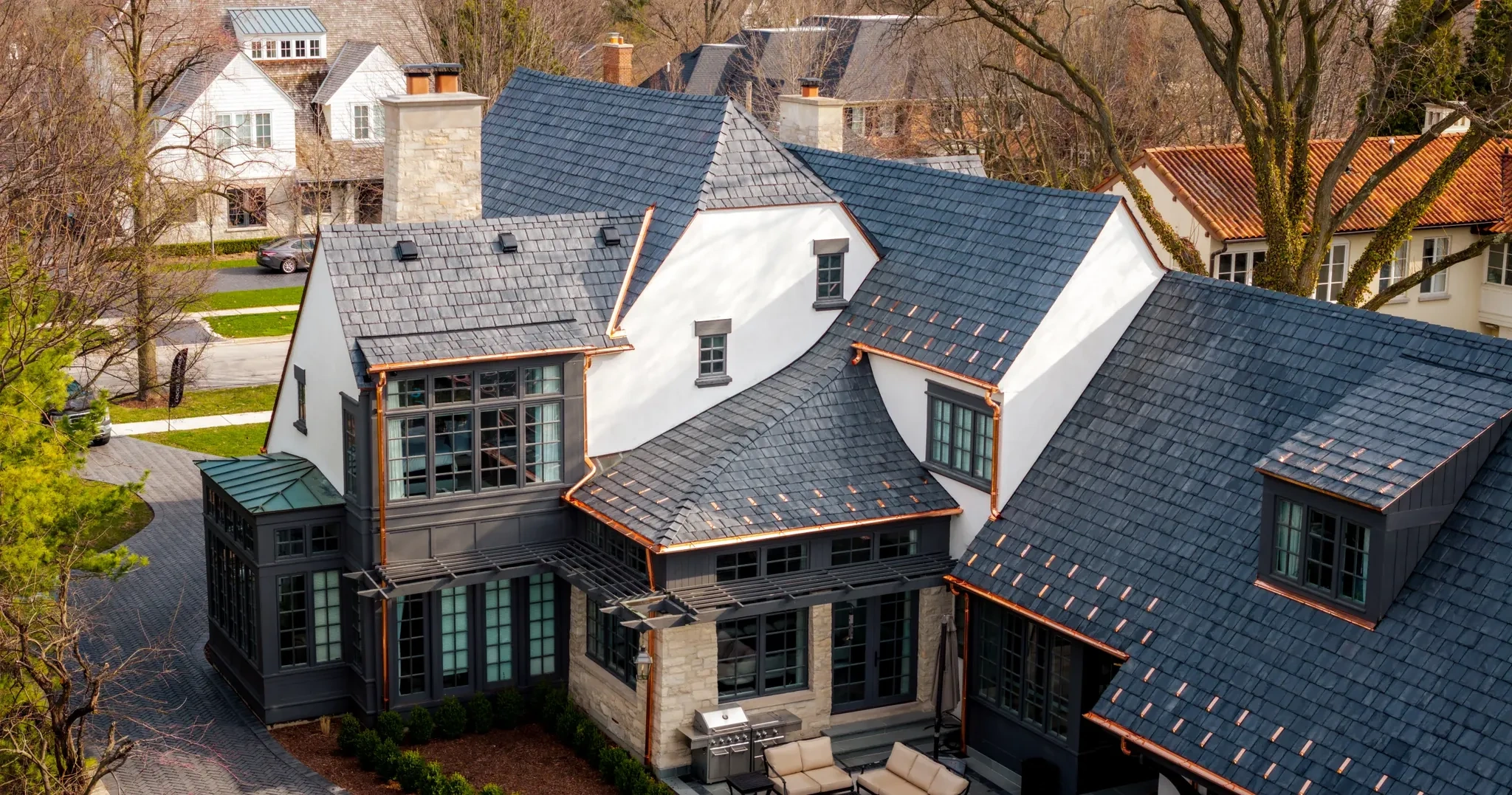Aerial rear roof and patio with full gutter system on the Hinsdale residence project