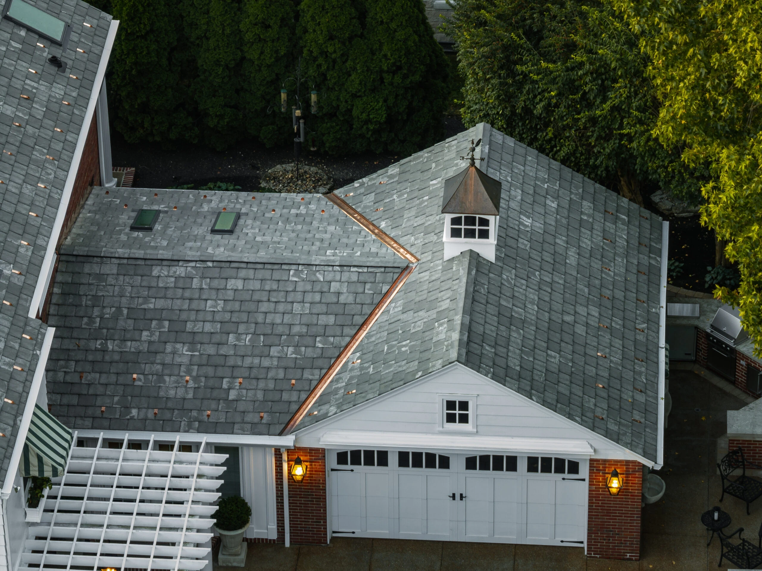 Aerial view of copper gutter runs following the edges of a slate-profile roof