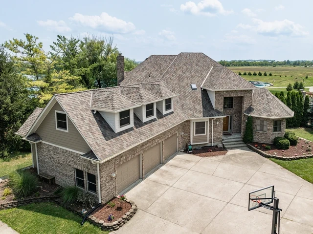 Roof and siding renovation on a lakeside stone residence in McCordsville, Indiana