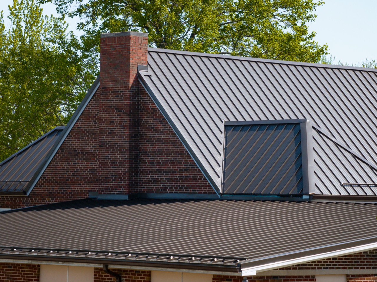 Close architectural view of commercial metal roof edges, transitions, and perimeter detailing