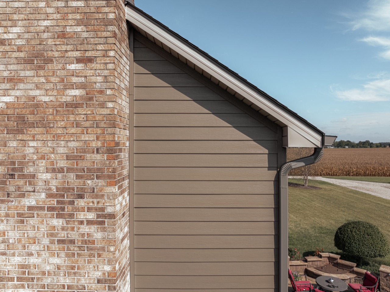Horizontal lap-siding courses terminating cleanly against brick and roof edges
