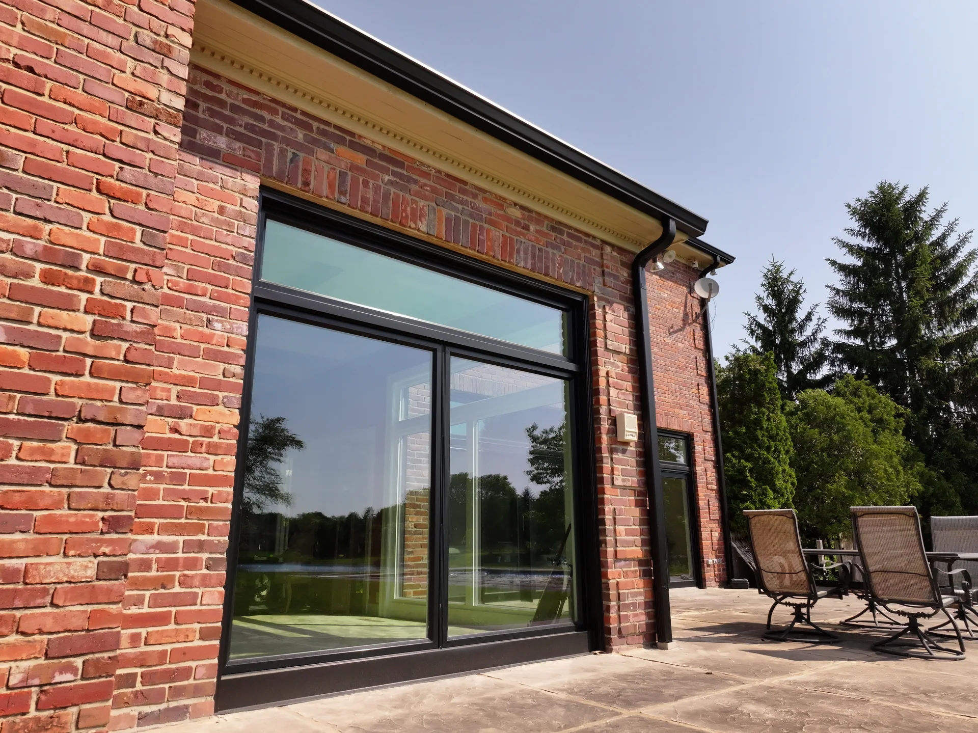 Black picture window and transom beside the patio in Carmel, Indiana