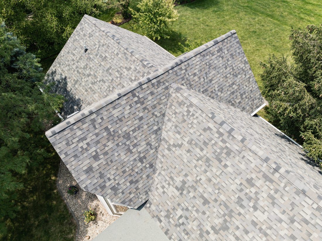 Overhead view of a finished polymer-modified asphalt shingle field, showing the courses, valleys, and ridge lines